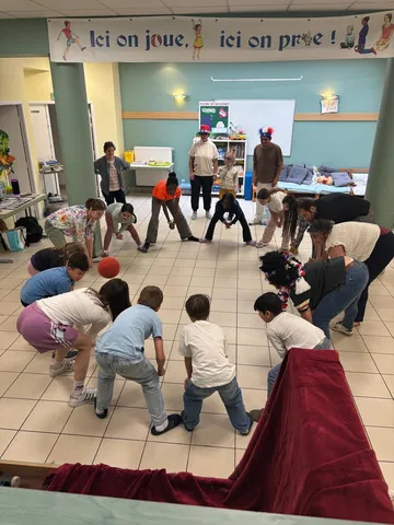 Des enfants qui jouent au sol dans la salle du patronage