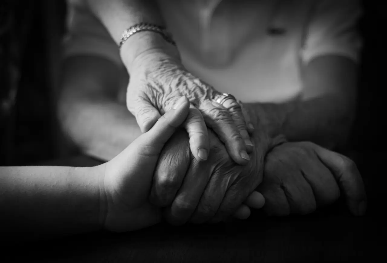 Une main d’enfant tenant une main très âgée